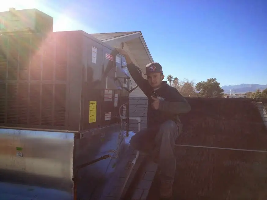 HVAC technician performing Heat Pump Repair on a rooftop unit in Ramsey